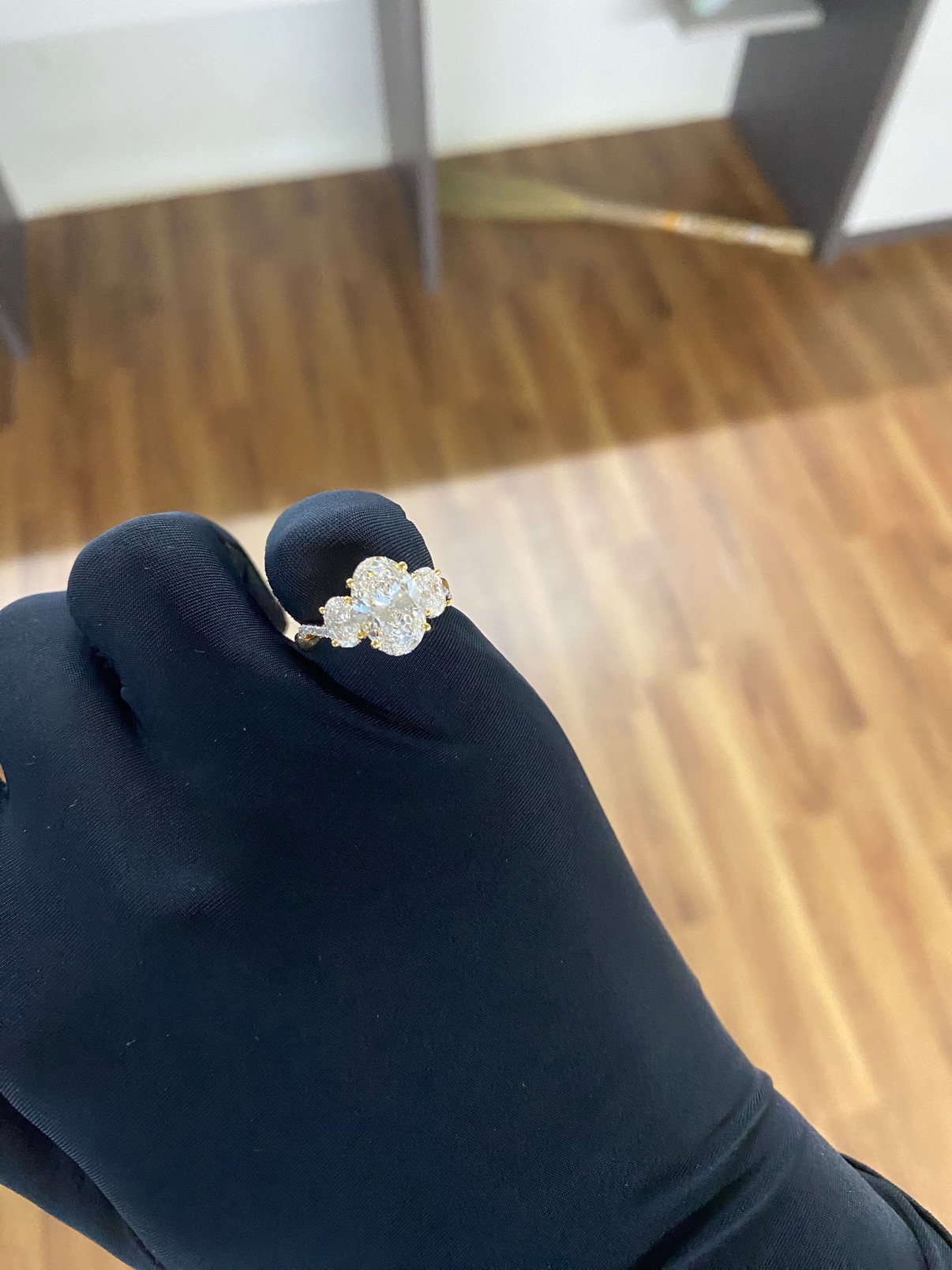 Oval three-stone engagement ring in solid 14K yellow gold, top view